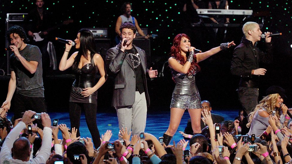Integrantes do RBD cantando no palco