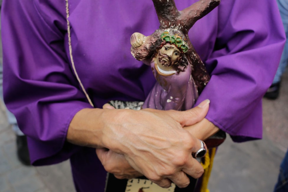 Peregrina con una figura de El Nazareno de San Pablo.