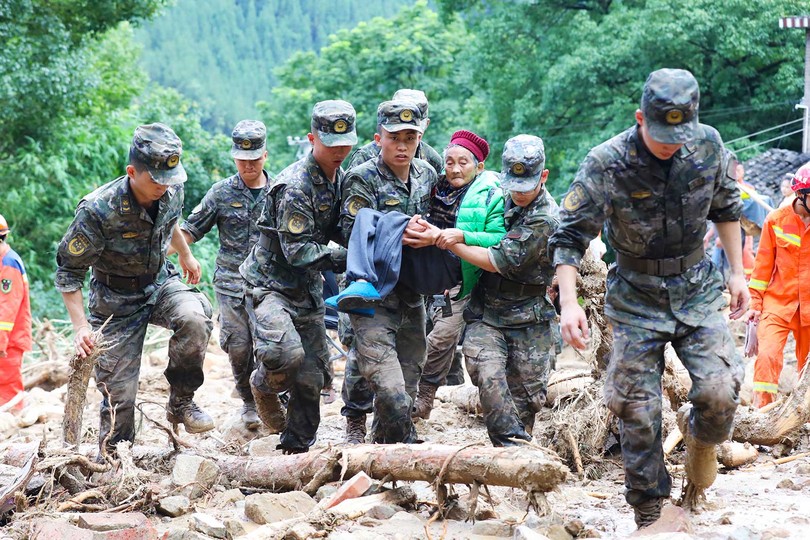 ​​Police carry an elderly woman who had been trapped after torrential rains triggered floods and landslides in Wanzhou district, in Chongqing, China -  4 July 2023