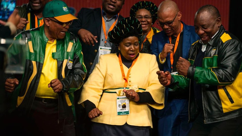 El presidente sudafricano Jacob Zuma (I) está apoyando a su exmujer, Nkosazana Dlamini-Zuma (C), frente a su vicepresidente , Cyril Rampahosa, (D) Jacob Zuma (I), su exmujer y su vicepresidente bailan tras el cierre de la conferencia política de su partido, el Congreso Nacional Africano, en Johannesburgo, el pasado 5 de julio.