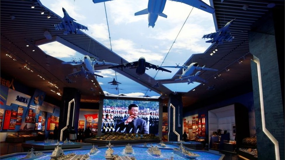 Models of military equipment and a giant screen displaying Chinese President Xi Jinping are seen at an exhibition at the Military Museum of the Chinese People"s Revolution in Beijing, China October 8, 2022