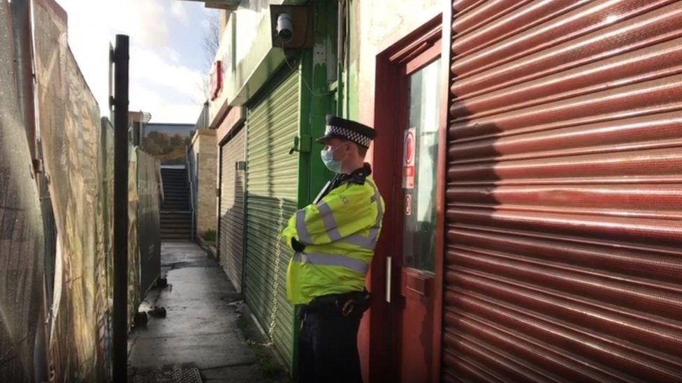 Police officer outside the Pay and Sleep hostel in The Crescent, Southall