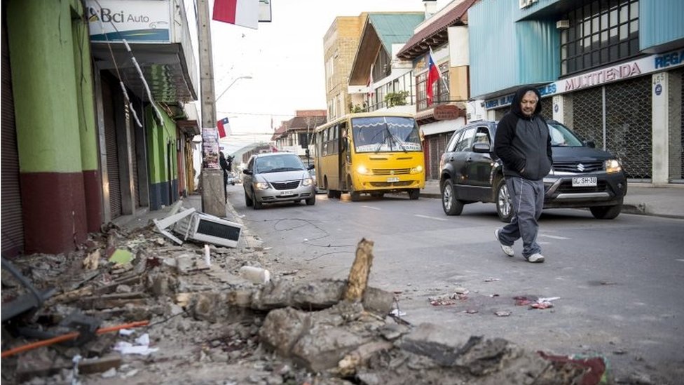 Мужчина переходит улицу рядом с обломками разрушенного дома после землетрясения в Иллапеле, примерно в 200 км к северу от Сантьяго 17 сентября 2015 года.