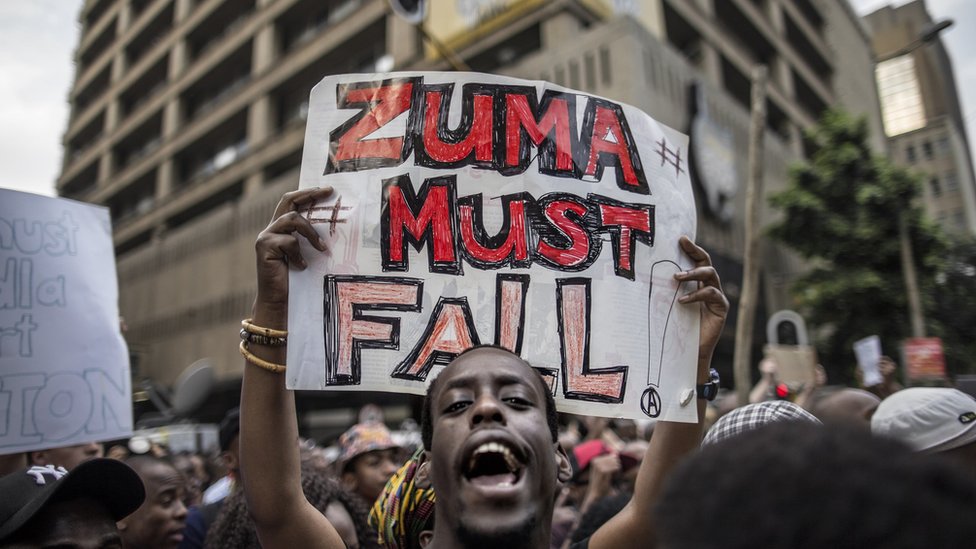 Студент держит плакат с надписью «Зума должен упасть» возле Дома Лутули, штаб-квартиры АНК, в Йоханнесбурге, Южная Африка - 22 октября 215