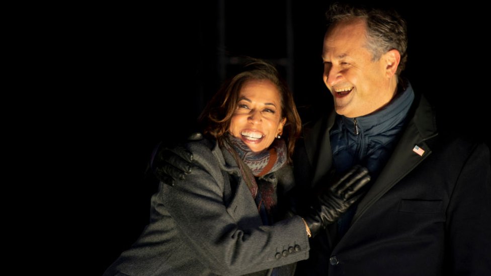 Democratic vice presidential nominee Sen. Kamala Harris (D-CA) and husband, Douglas Emhoff, embrace on stage after Democratic presidential nominee Joe Biden spoke in Pittsburgh at a simultaneous drive-in election eve rally on November 2, 2020 in Philadelphia, Pennsylvania