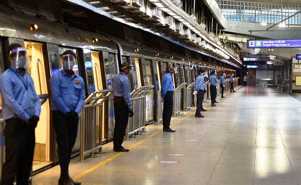 Security guards wearing face shields seen beside a train at Rajiv Chowk Metro Station during a press preview of Delhi Metro Rail Corporation (DMRC) preparedness ahead of metro services resuming on September 3, 2020