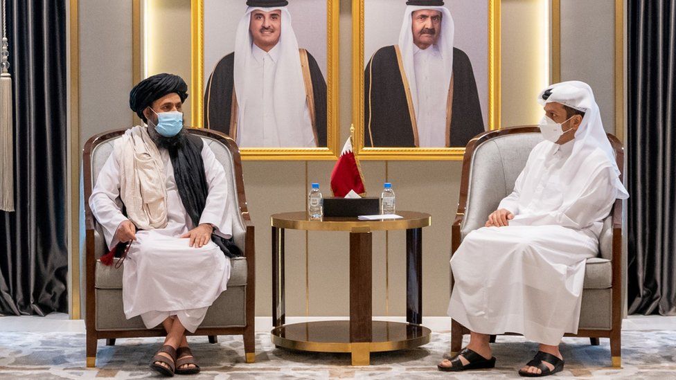 الزعيم السياسي لطالبان عبد الغني برادار مع مسؤول قطري