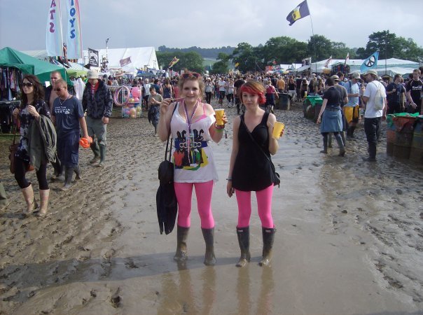 Две женщины в резиновых сапогах стоят в грязи