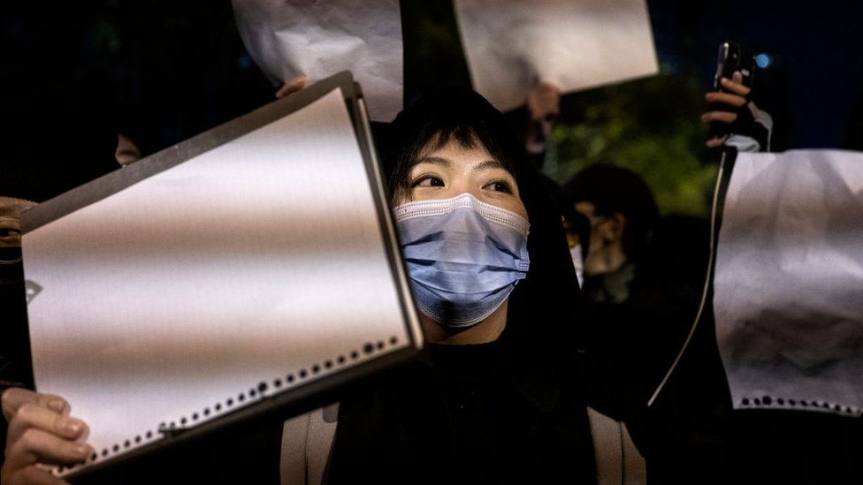 Manifestante portando una hoja en blanco en una manifestación en Pekín