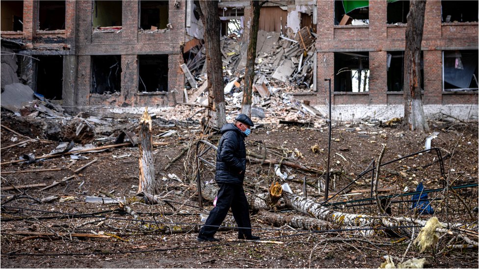 Un hombre camina frente a un edificio destruido en Vasylkiv