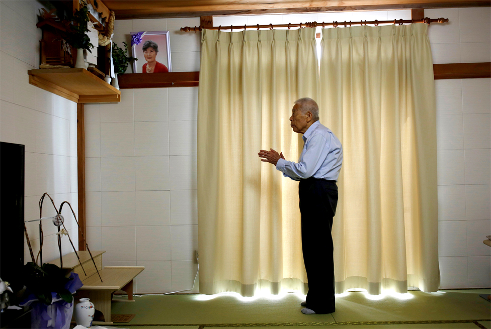Ryuichi Nagayama prays at an altar at his home