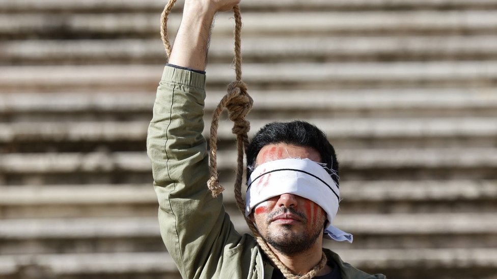 رجل يحتج في لشبونة على إعدام إيران لرجلين في ديسمبر بسبب الاحتجاجات المناهضة للحكومة