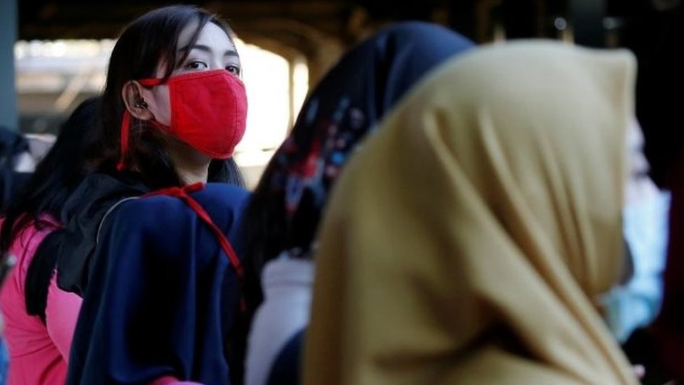 Penumpang kereta di Jakarta menggunakan masker.