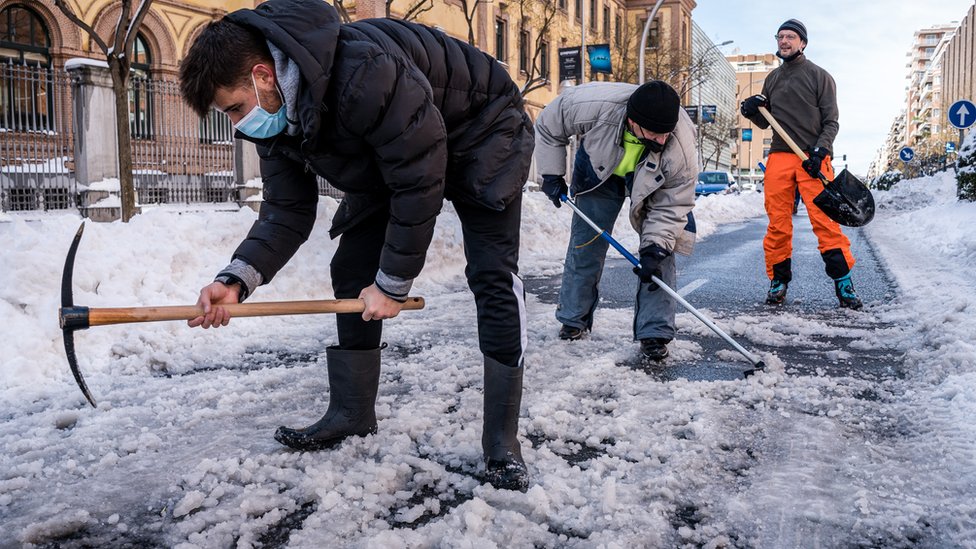 Neighbours clearing the snow in the streets that connect with the Gregorio Marañon Hospital in Madrid