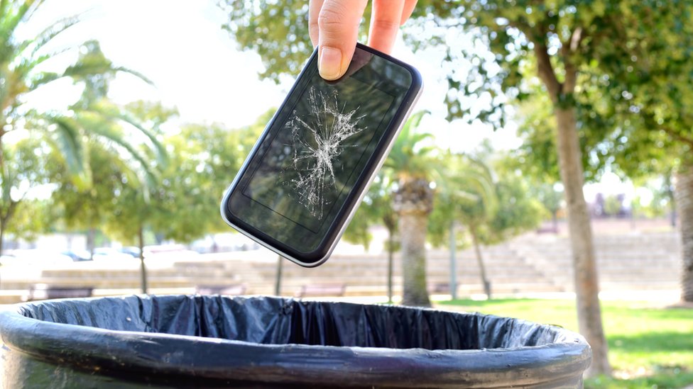 tirando un iphone a la basura