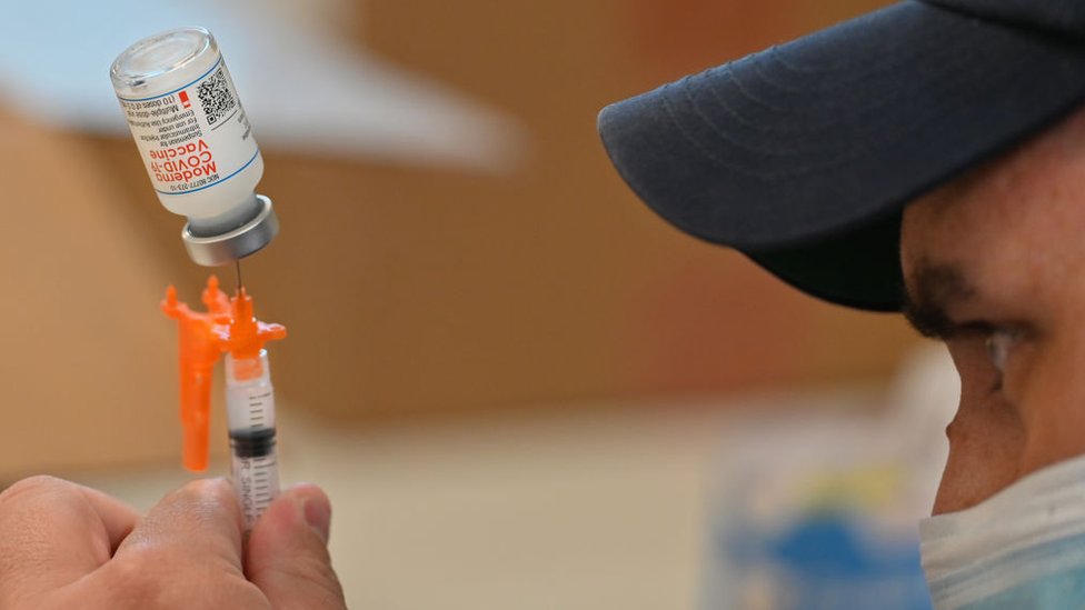 Un trabajador sanitario con una vacuna de Moderna.