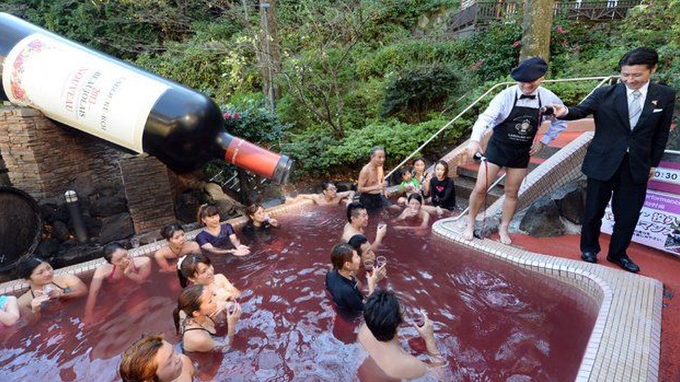 Вино Beaujolais Nouveau наливают в винный спа-центр Hakone Yunessun в городе Хаконе, Япония