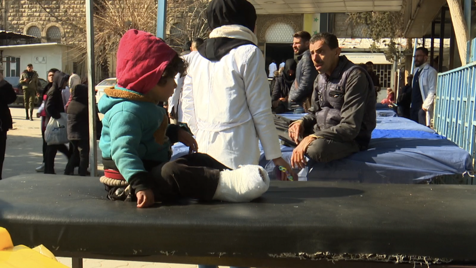 طفل يجلس على سرير خارج المستشفى.