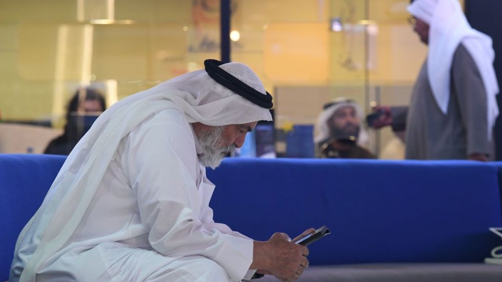 Мужчина в Дубае пользуется мобильным телефоном