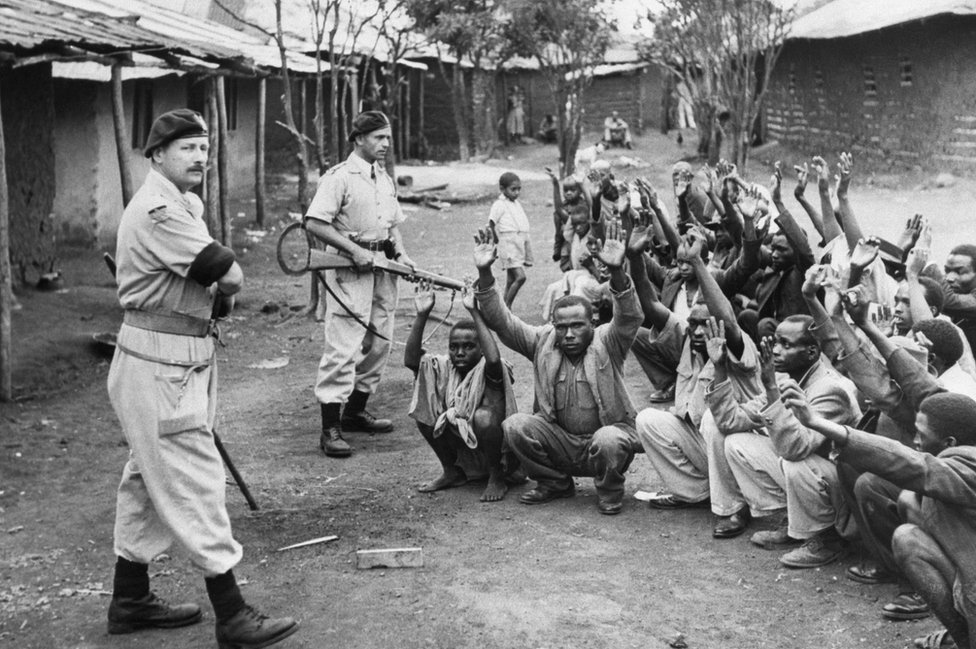 Британские полицейские держат подозреваемых Мау-Мау под прицелом в 1952 году.