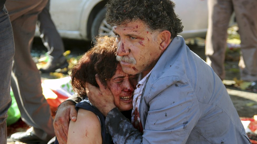 Раненый мужчина обнимает раненую женщину после взрывов во время марша мира в Анкаре, Турция, 10 октября 2015 года.