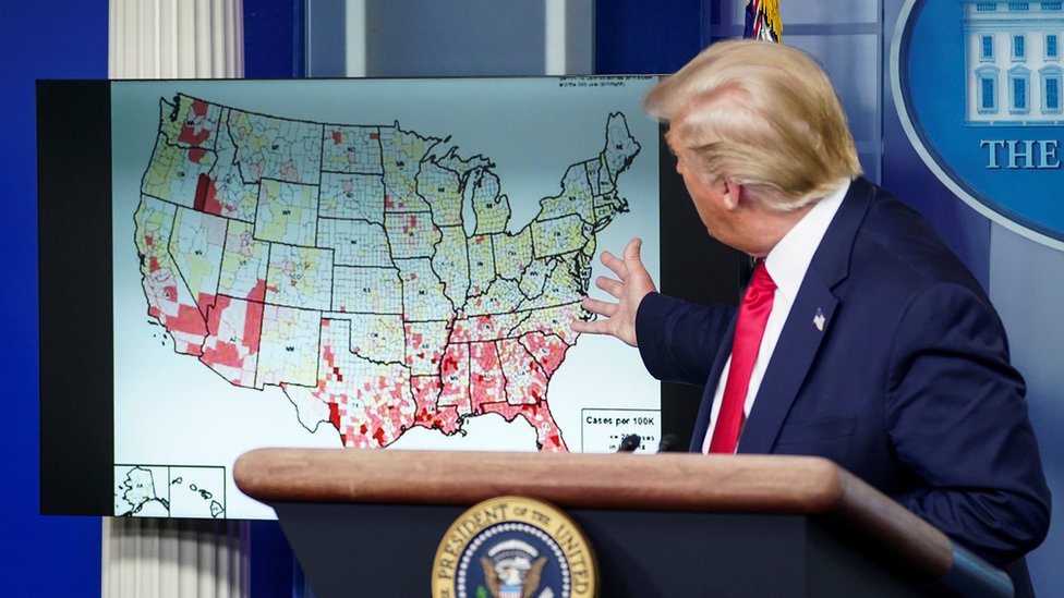 Президент США Дональд Трамп указывает на карту зарегистрированных случаев коронавируса, когда он говорит о возобновлении работы школ во время брифинга новостей о коронавирусе в Белом доме в Вашингтоне