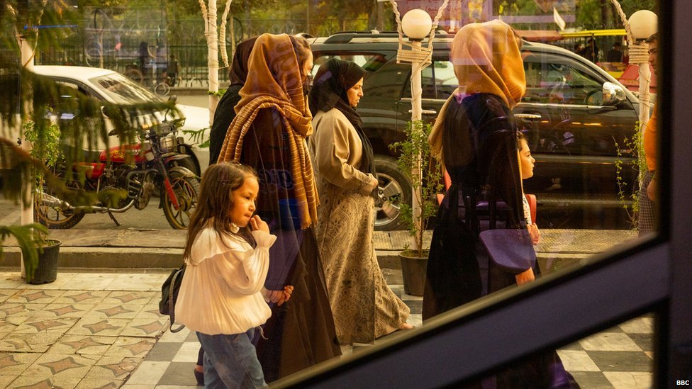 Sekelompok perempuan berjalan melintas depan sebuah restoran di Kabul.