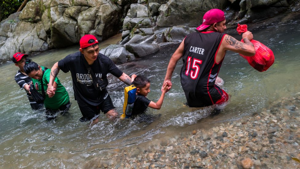 Migrantes cruzando el Darién.