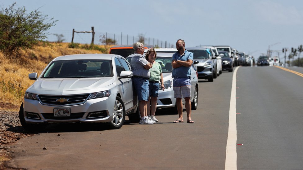 Pessoas esperam na beira da estrada para retornar ao oeste de Maui, depois que incêndios florestais provocados por ventos fortes destruíram grande parte da cidade histórica de Lahaina