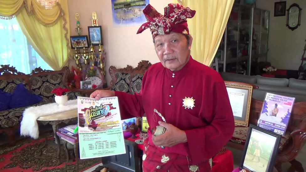 Agus MD memegang undangan acara festival gasing saat dijumpai di rumahnya di Pangkalpinang, Bangka Belitung.