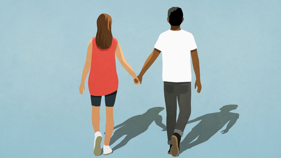 Multiethnic couple holding hands and walking