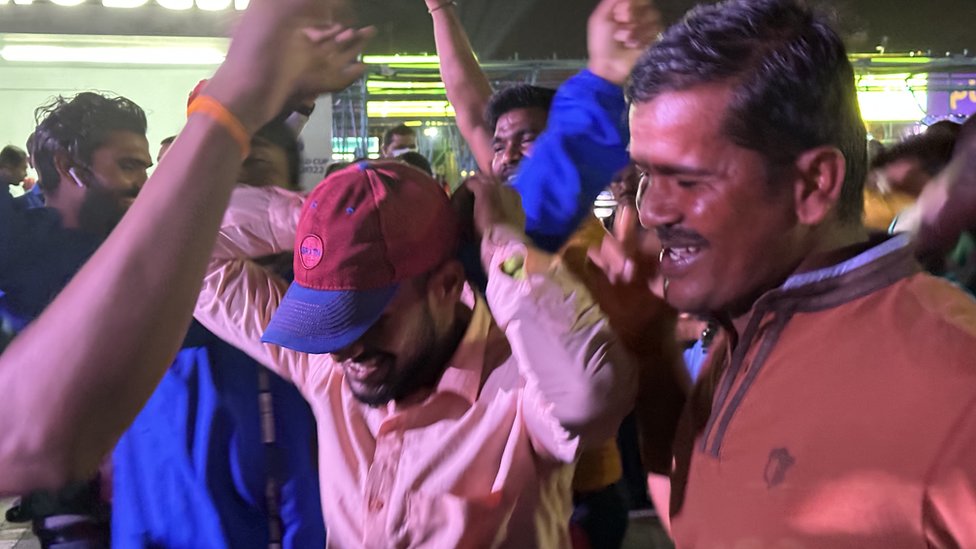Migrantes bailan antes del inicio de un partido del Mundial en la zona fan de la Zona Industrial.