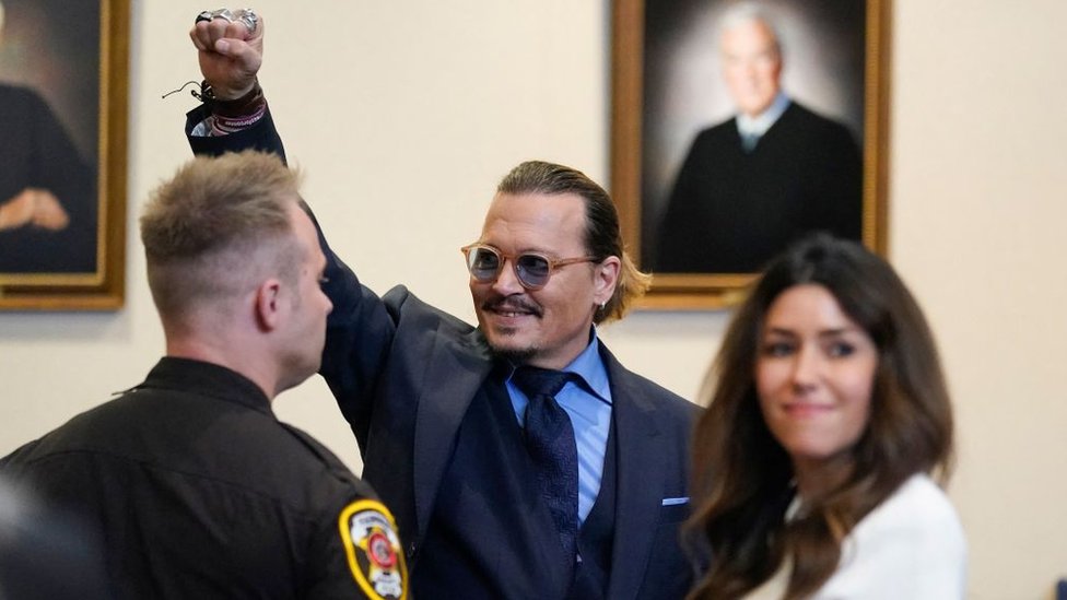 Johnny Depp alza el puño en señal de victoria en el tribunal.