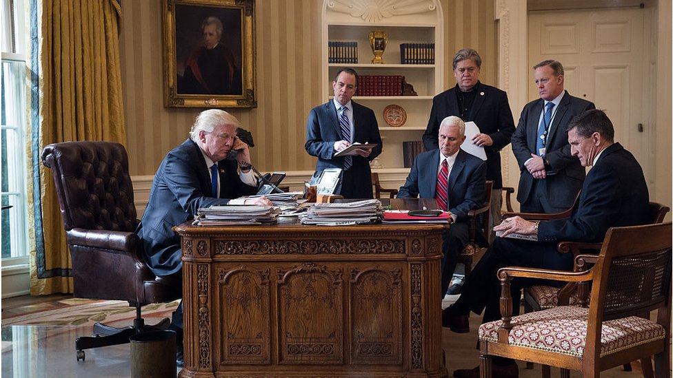 Donald Trump hablando por teléfono con Vladimir Putin en el Despacho Oval en enero de 28, 2017 en Washington, DC. De izquierda a derecha, el ex jefe de gabinete de la Casa Blanca, Reince Priebus; el vicepresidente Mike Pence; el ex jefe de estrategia de la Casa Blanca, Steve Bannon; el ex secretario de prensa Sean Spicer y el ex asesor de seguridad nacional Michael Flynn.