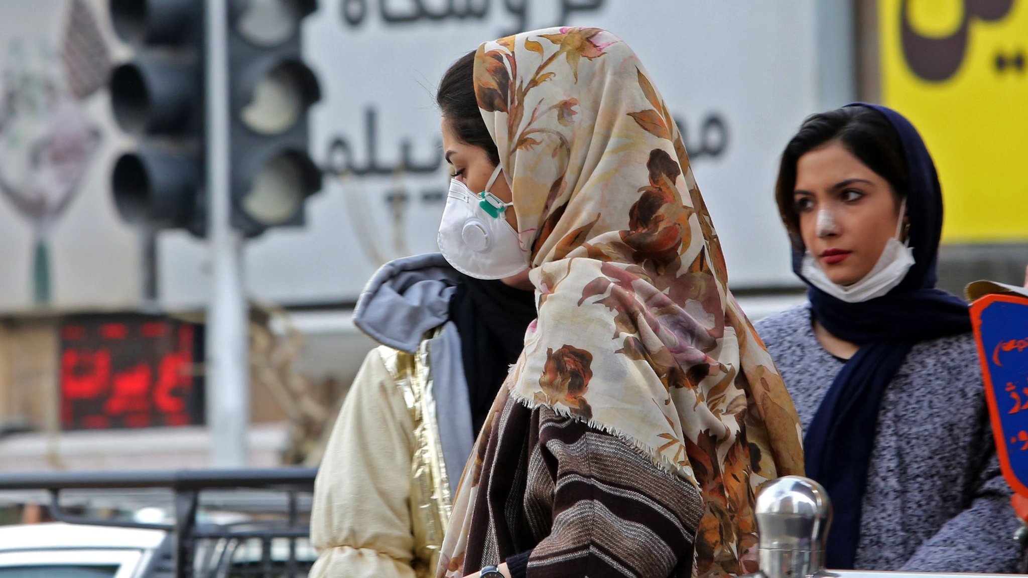 Женщина в маске идет по улице в Тегеране, Иран (24 февраля 2020 г.)