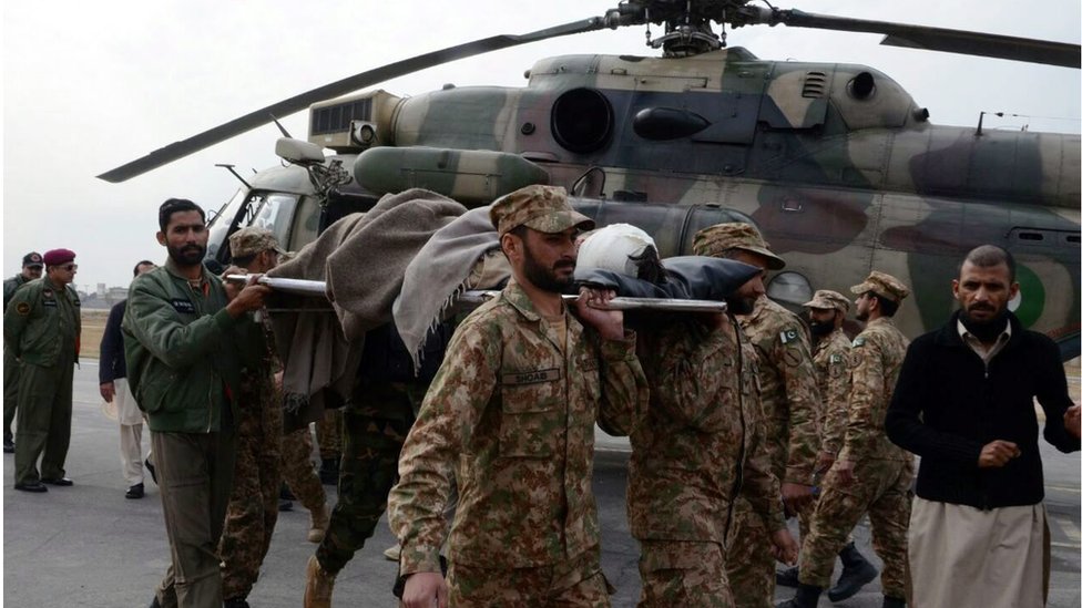 Пакистанские солдаты, идущие с носилками перед вертолетом, несут раненую жертву взрыва бомбы в Парачинаре, Пешавар, Пакистан, 21 января 2017 года.