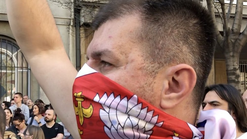 Jedan od demonstranata na protestu nosi zastavu Srbija kao maramu preko lica