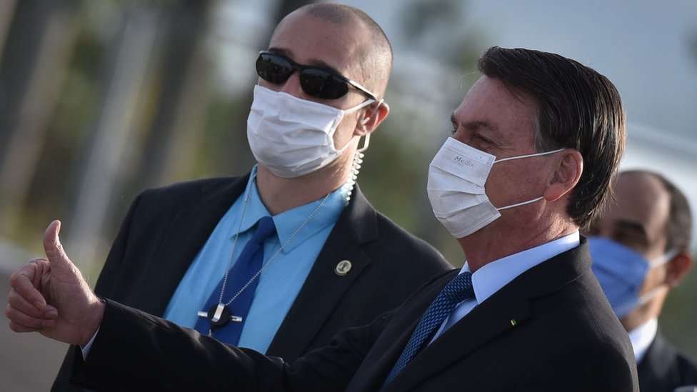 Президент Бразилии Жаир Болсонару в защитной маске прибывает на церемонию поднятия государственного флага перед дворцом Альворада в связи с пандемией коронавируса (COVID-19) в Бразилиа, Бразилия, во вторник, 9 июня 2020 г.