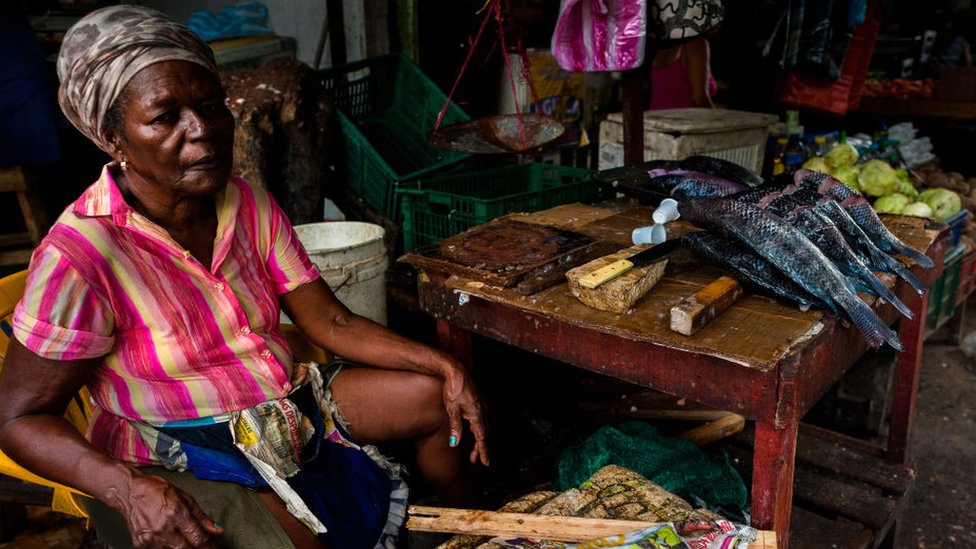 A woman sells fish in Colombia