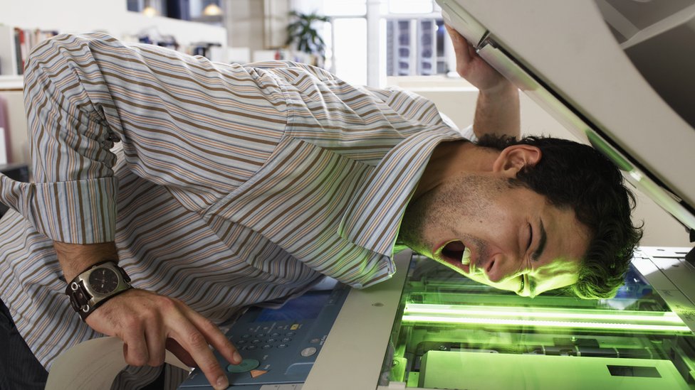 Godinear se usa como verbo para decir hacer actividades propias de los Godínez. (Foto: Getty/Christopher Robbins) Hombre haciendo copias de su cara en una fotocopiadora