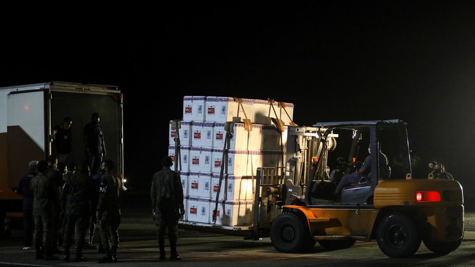 Lotes de doses da vacina Coronavac são transportadas em caixas e levadas para um caminhão