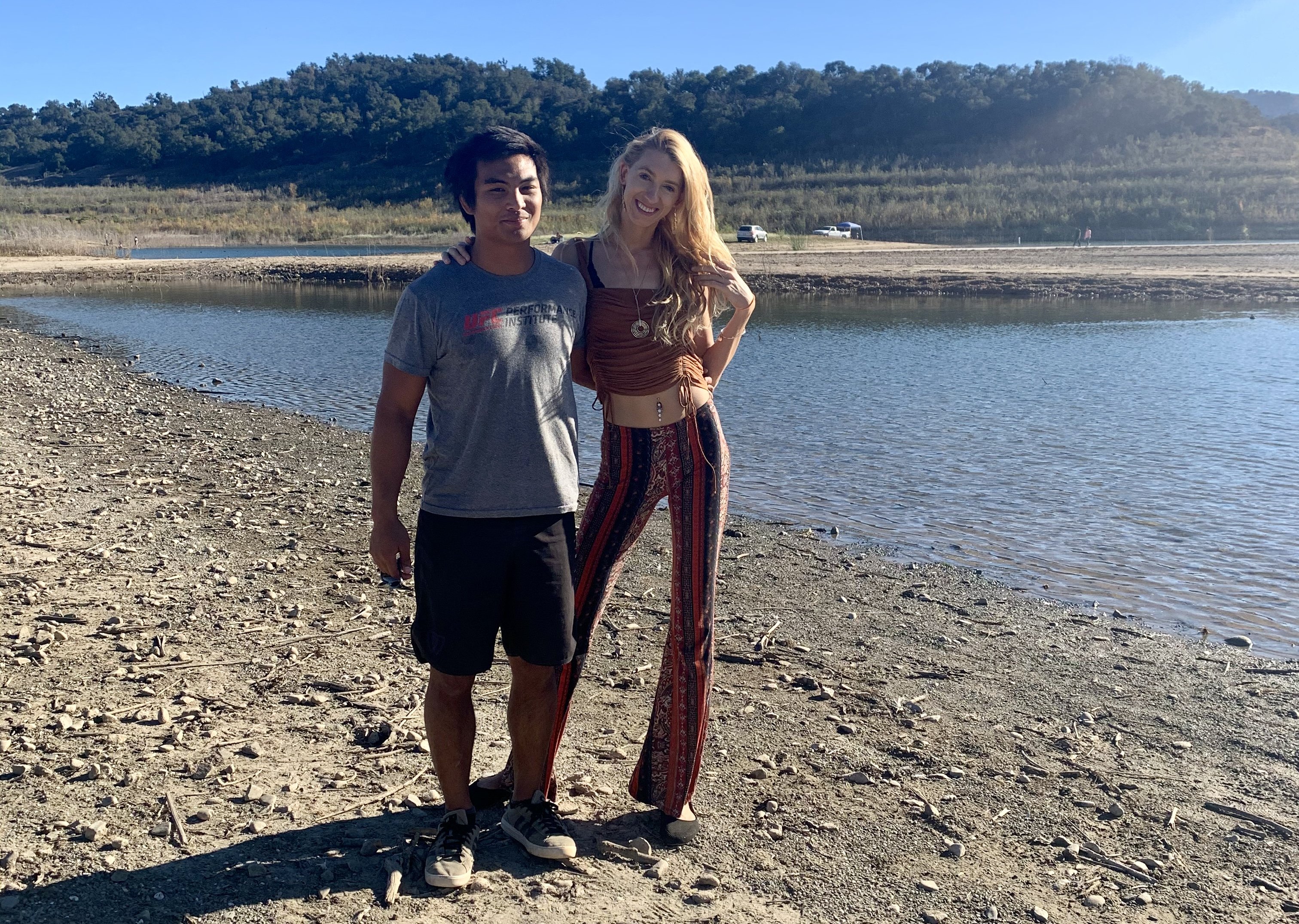 Josh e Daniella posam para foto perto de lago