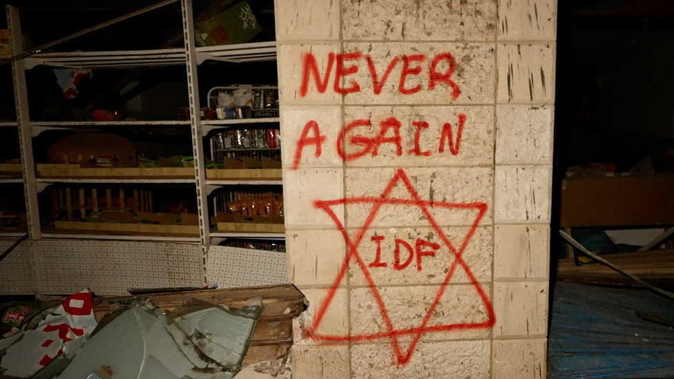 A Star of David spray-painted on a wall south of Gaza City, with the word "IDF" written inside it, and above it, the words: "Never Again"