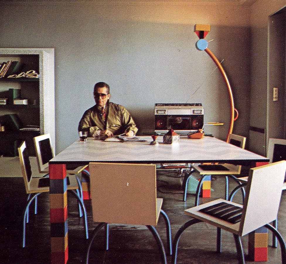 Карл Лагерфельд сидит в своей квартире в Монте-Карло с дизайном от Memphis Group, включая стол «Pierre» от Соудена и светильник «Treetops» от Соттсасс