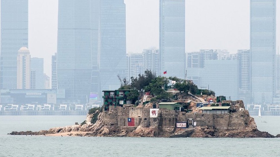 台灣金門離島小島——獅嶼。島上插有中華民國國旗，對面高樓大廈是福建廈門市（2018年4月20日資料照片）。