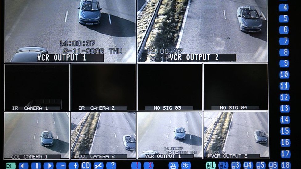 Телевизионный монитор показывает результаты камер видеонаблюдения и инфракрасных камер распознавания автомобильных номеров, отслеживающих автомобили, движущиеся по автомагистрали M62 в Чешире