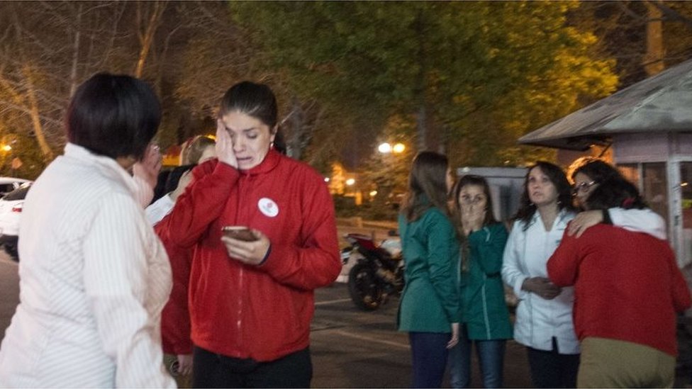 Женщины остаются на улице во время сильного землетрясения в Сантьяго 16 сентября 2015 года.