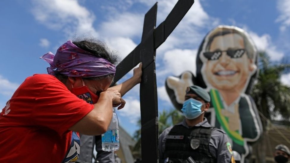 A protester holds a cross at a protest against Bolsonaro and his handling of the pandemic. File photo