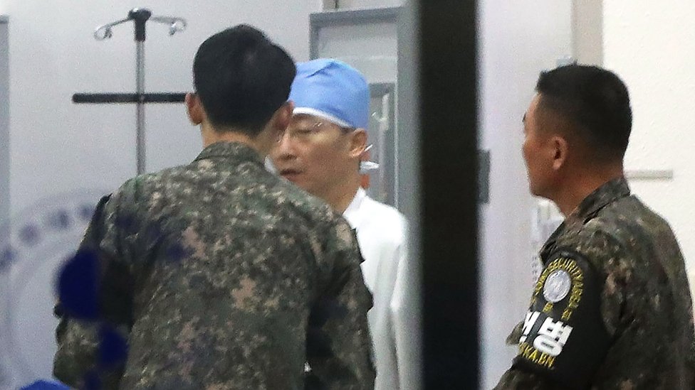 Los medios retrataron el lunes a un médico conversando con miembros del ejército surcoreano que llevaban identificación de la Zona de Seguridad Conjunta en un hospital de Suwon, en el sur de Seúl. Los medios retrataron el lunes a un médico conversando con funcionarios del ejército surcoreano que llevaban identificación de la Zona de Seguridad Conjunta en un hospital de Suwon, en el sur de Seúl.