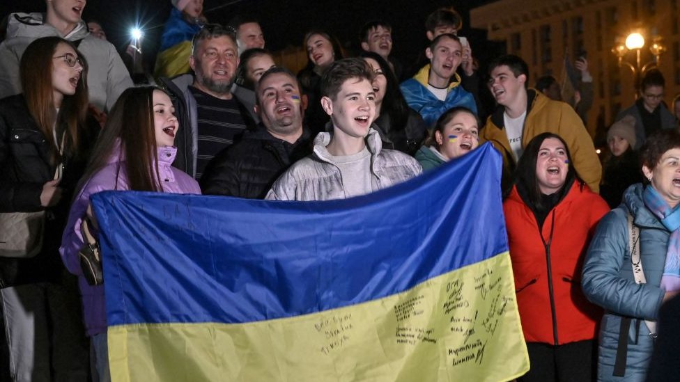 Ucranianos muestran su bandera en la Plaza de la Independencia en Kyiv.
